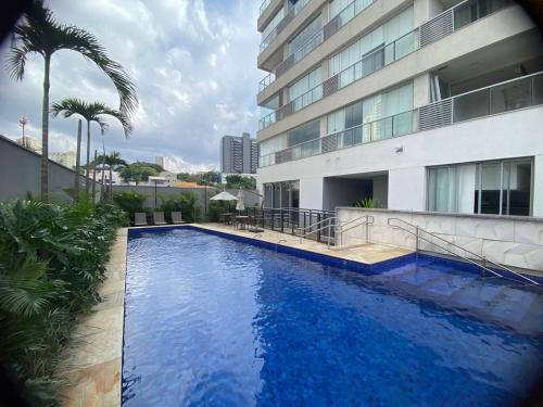 a large blue swimming pool next to a building at Studio Patteo Bosque Maia in Guarulhos