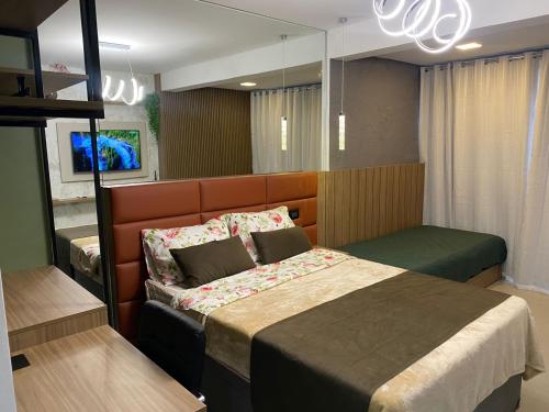 a bedroom with a bed in a room with a chandelier at Studio Patteo Bosque Maia in Guarulhos