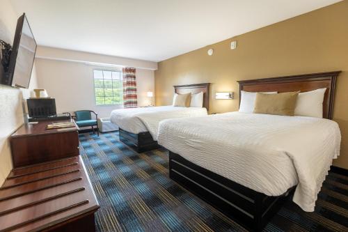 a hotel room with two beds and a television at Rosebud Inn in Branson