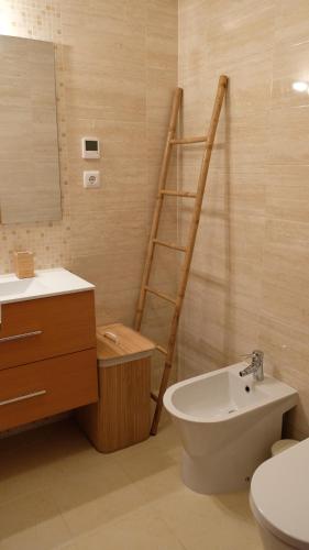 a bathroom with a ladder next to a toilet and a sink at Peniche Supertubos Terrace in Peniche