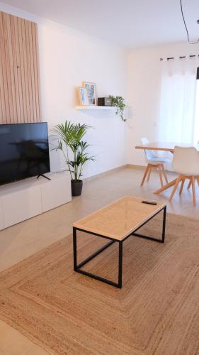 a living room with a coffee table and a tv at Peniche Supertubos Terrace in Peniche