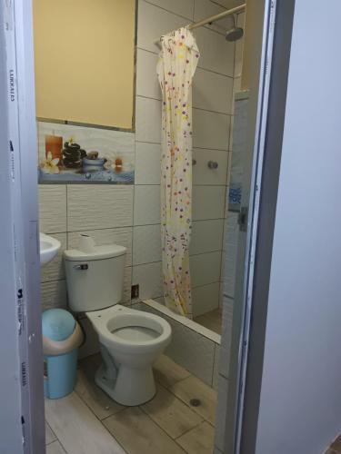 uma casa de banho com um WC e uma cortina de chuveiro com granulados em El Amauta de los Andes Lodging Erik House em Huaraz