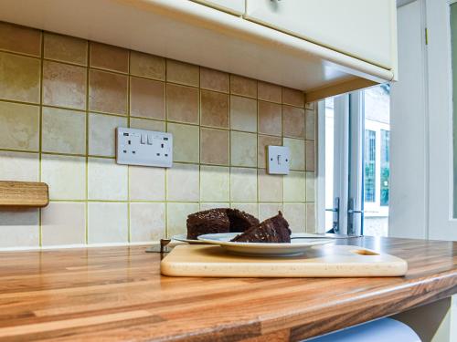 a plate of cake on a counter in a kitchen at Low View in Chelmorton