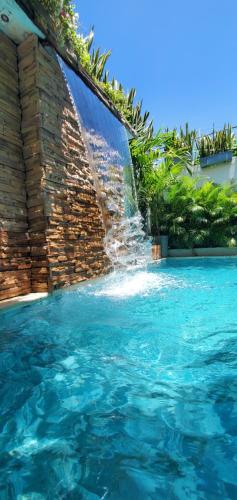 a swimming pool with a water fountain at Ritacuba House Boutique in Santa Marta