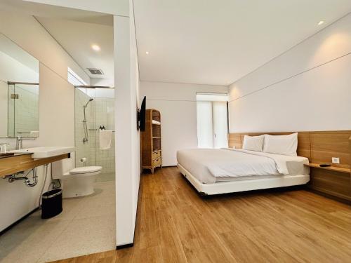 a bedroom with a large bed and a bathroom at Bungalow Homes in Bandung