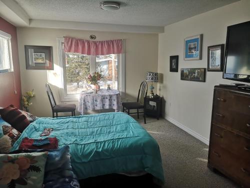 um quarto com uma cama, uma mesa e uma janela em Paradise Inn em North Bay