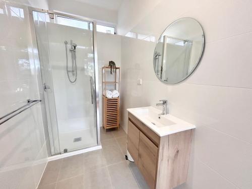 a bathroom with a sink and a shower and a mirror at Sandford Views - Deluxe Studio in Sandford