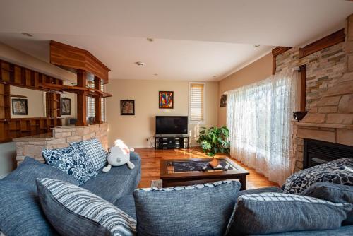a living room with blue couches and a fireplace at Goodview Le Mont-Luc in Gatineau