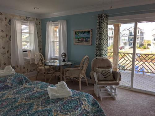 1 dormitorio con 2 camas, mesa y sillas en 2508 Beach Rd, Semi-Oceanfront, Pool/Hot Tub en Nags Head
