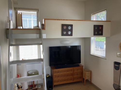uma sala de estar com um beliche e uma televisão em art.paradigm em Kushiro