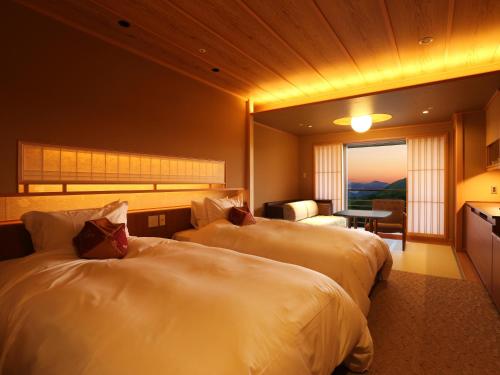 神戸市にある有馬グランドホテルのベッド2台とリビングルームが備わるホテルルームです。