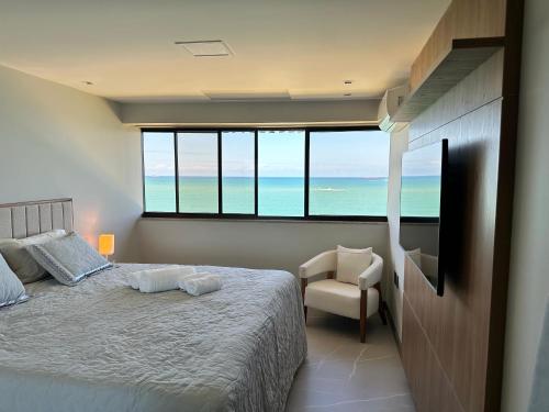 a bedroom with a bed with a view of the ocean at Aconchegante FLAT 807 in Vila Velha