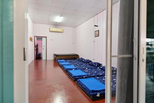 a row of blue beds in a room at Rub Lom Chom Klong Homestay in Chumphon