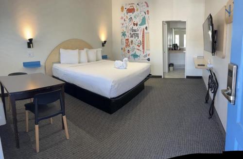 Habitación de hotel con cama, mesa y escritorio. en Ocean Palms Motel, en Pismo Beach