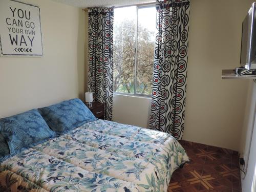 Un dormitorio con una cama y una ventana con cortinas. en LO MEJOR DE BOGOTAa, en Bogotá