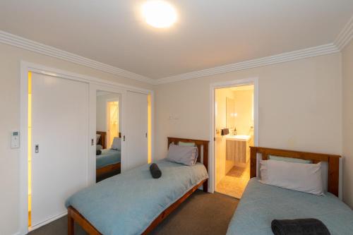 a bedroom with two beds and a bathroom at Armidale Cottage - House 1 in Armidale