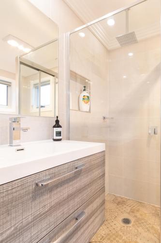 a bathroom with a sink and a mirror at Armidale Cottage on Barney - House 1 in Armidale
