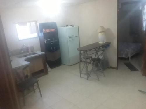 eine kleine Küche mit einem Tisch und einem Kühlschrank in der Unterkunft Cabaña Omnia in Pocito