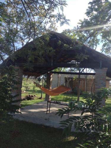 een tuinhuisje met een hangmat in de tuin bij Carmen del Paraná Sandra Hostel in Carmen del Paraná