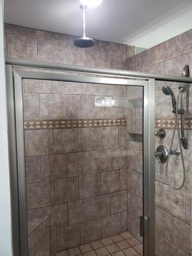 een douche met een glazen deur in de badkamer bij The Moise Manor in Sumter