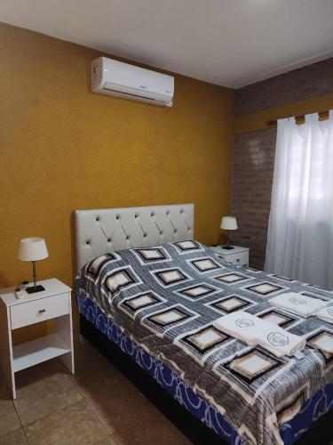 a bedroom with a bed and two tables with lamps at Complejo M&M in Bialet Massé