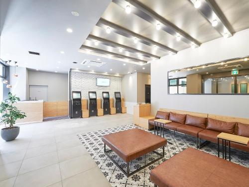 a lobby with a couch and a waiting room at Sotetsu Fresa Inn Kobe Sannomiya in Kobe