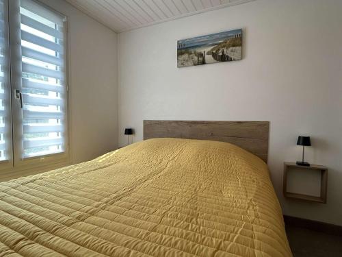 - une chambre avec un lit doté d'une couette jaune et d'une fenêtre dans l'établissement Maison Noirmoutier-en-l'Île, 2 pièces, 6 personnes - FR-1-224B-195, à Noirmoutier-en-l'lle
