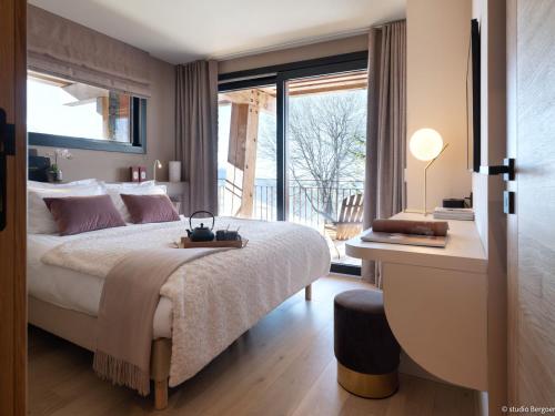 une chambre avec un lit et une grande fenêtre dans l'établissement Grand chalet avec piscine intérieure, spa et salle de jeux - FR-1-686-31, à Arc 1800