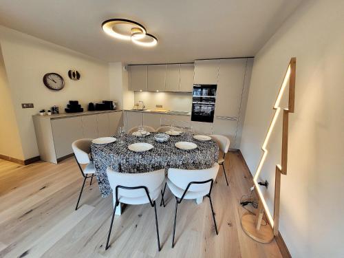 une table de salle à manger avec des chaises et une cuisine dans l'établissement Appartement prestige 6 pers, centre Les Gets, à 150m des pistes, avec terrasse et équipements luxueux - FR-1-598-147, aux Gets