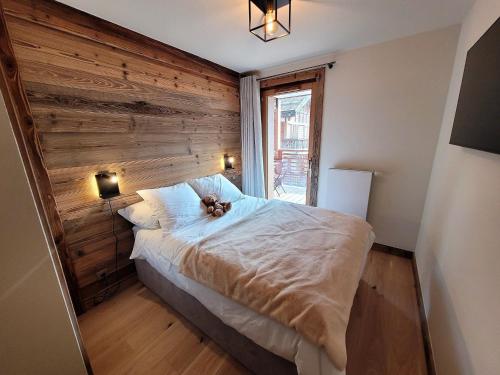 une chambre avec un lit avec un ours en peluche dessus dans l'établissement Appartement prestige 6 pers, centre Les Gets, à 150m des pistes, avec terrasse et équipements luxueux - FR-1-598-147, aux Gets