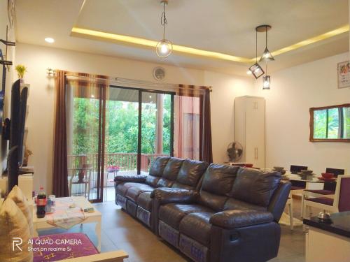 a living room with a leather couch and a table at Vimala Hills FARLA Villa - 3BR in Gadok 1