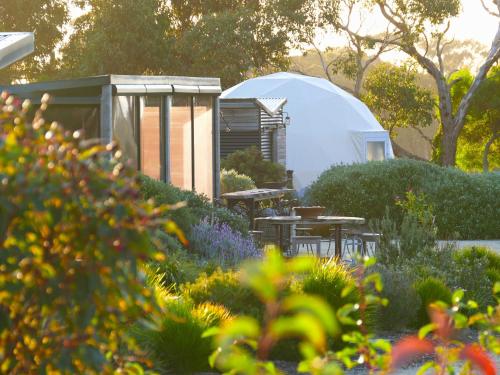 a garden with a tent and tables and flowers at Inverloch Glamping in Inverloch