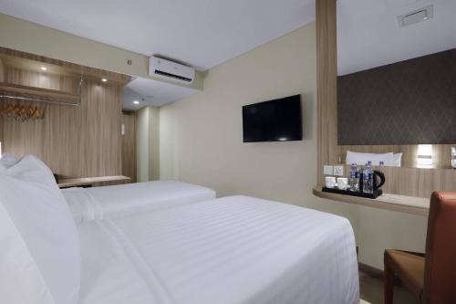a hotel room with two beds and a tv at Aston Nagoya City Hotel in Nagoya
