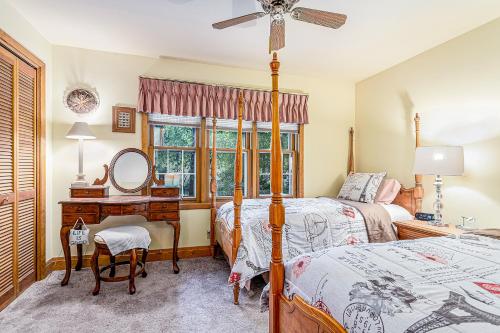 1 dormitorio con 2 camas y escritorio con espejo en Barton Cottage, en New Buffalo