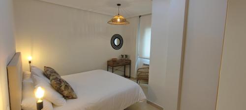 a bedroom with a white bed and two candles at La Figar,apartamento con piscina, playa a 3km VUT-4390-AS in Llanes