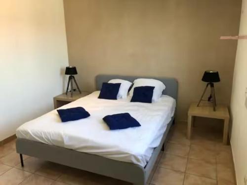 Un dormitorio con una cama con almohadas azules. en Très bel appartement Nice vue mer en Niza