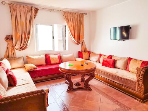 sala de estar con sofá y mesa en Résidence Jawhara, luxe, piscine et en face à la mer en Oued Laou