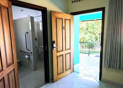 an open door to a bathroom with a shower at Pousada Casa Rosa in Alto Paraíso de Goiás