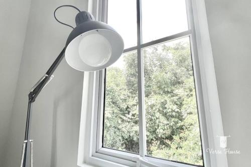 eine Lampe, die vor einem Fenster sitzt in der Unterkunft Verse House in Pontianak