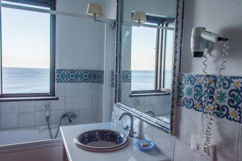 a bathroom with a sink and a mirror at Hotel Rocce Azzurre in Lipari