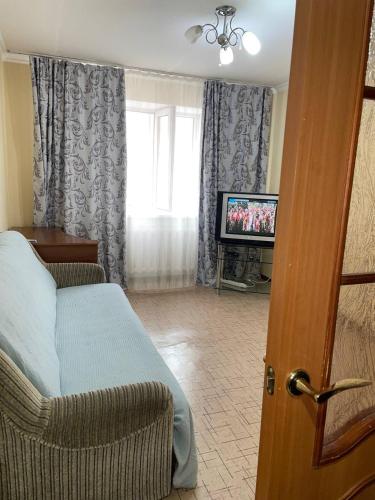 a living room with a bed and a television at Аэропорт Астана 5 минут юг1 in Astana