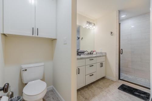 La salle de bains blanche est pourvue d'une douche et de toilettes. dans l'établissement The Urban Haven of Fort Worth, à Fort Worth