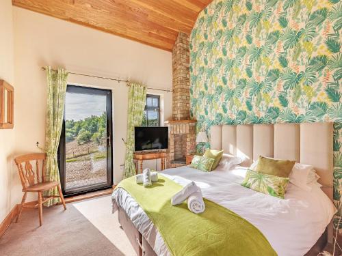 a bedroom with a large bed and a tv at The Granary - Uk36673 in Goulsby