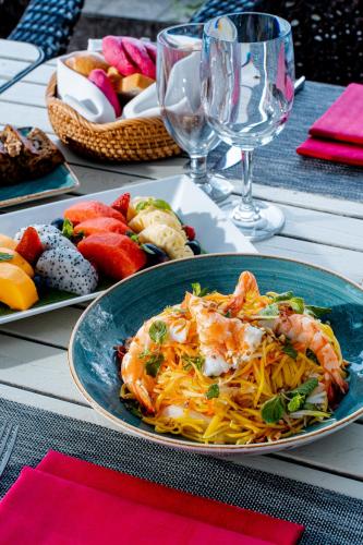 a table with a plate of food with shrimp and fruit at Sedona Suites Ho Chi Minh City in Ho Chi Minh City