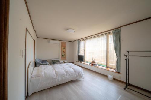 1 dormitorio con cama y ventana grande en 小樽民泊太田2号館 en Otaru