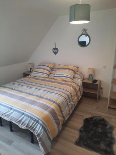une chambre avec un lit avec une couverture rayée dans l'établissement Le clos des rêves à 5km de dieppe, à Martin-Église