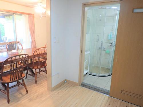 uma cozinha e sala de jantar com uma mesa e um chuveiro em 北谷 vacation house MALAPUA em Chatan