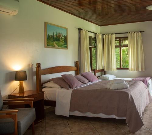 a bedroom with two beds and a window at Pousada Casa Rosa in Alto Paraíso de Goiás