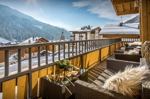 a balcony with chairs and a view of a mountain at Chalet Alyssum - OVO Network in Le Grand-Bornand