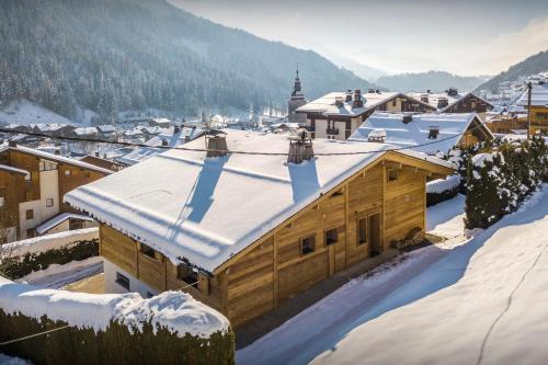a wooden building with snow on top of it at Chalet Alyssum - OVO Network in Le Grand-Bornand
